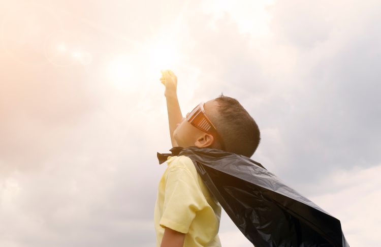 powerful call to action phrases - little kid dressed as superhero with fist in the air